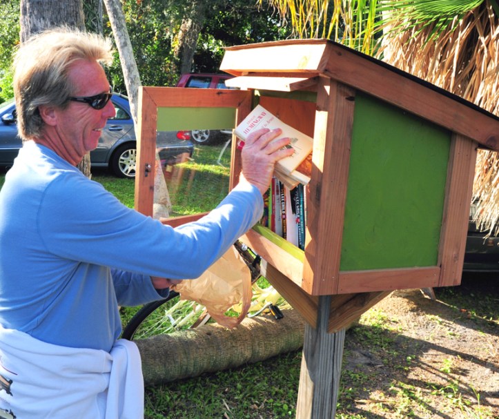 A resident of Old Riomar contributes  books to the "Little Library" in front of J.J. Wilson's home on Riomar Drive.