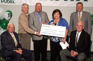 Tricia Jenkins, Treasure Coast Food Bank Director of Development, receives a grant check from Publix executives from the 2012 Food For All campaign.