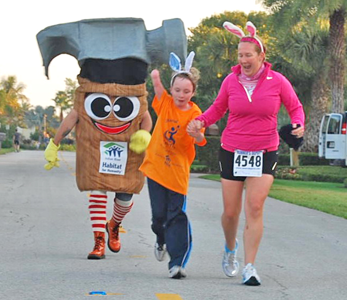 Cynthia Falardeau, Indian River County Junior League "Woman of the Year," and her son Wyatt  join Hamilton the Hammer as they head for the finish line in the 1-Mile Bunny Hop portion of Indian River Habitat for Humanity’s HabiTrot to Higher Education 5K run/walk event March 30.