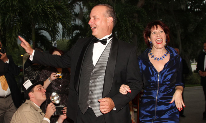 Sheriff Deryl Loar and his partner Patti Rooney make their way past the paparazzi