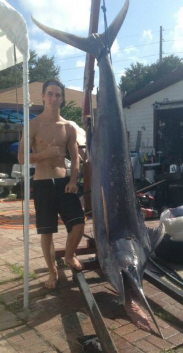 CONTRIBUTED PHOTO Trenton Finch, 17, of Vero Beach stands next to the 200-pound, 11-foot-long blue marlin he and friend Chris Botkin picked up at Vero Beach’s Jaycee Park on Monday.