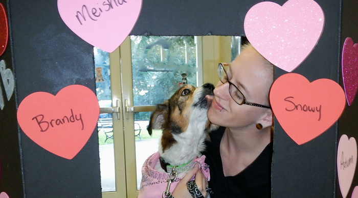 Humane Society staff member Emily Lanham and shelter dog Panch test out the "Smooch a Pooch" booth in preparation for Valentine's Day. 