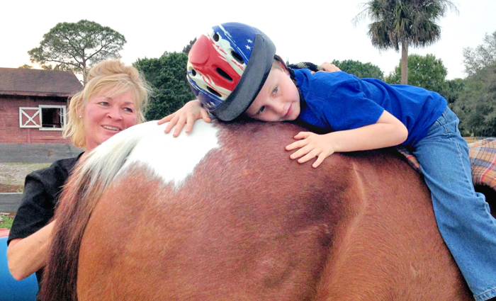 Cindy Devine, executive officer of the Florida Equestrian Foundation, with Vinny Henry, who is giving 19 year old Napolean a big hug.