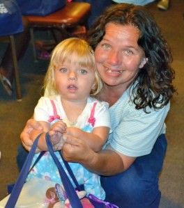 A mother and her daughter from the Homeless Family Center hold the bag of goodies donated to the children. 