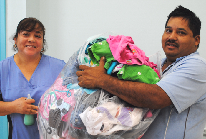 It took two, Eliza Vargas and Juan L. Rendon, to lug out all the clothes and toys at the Giving Closet.