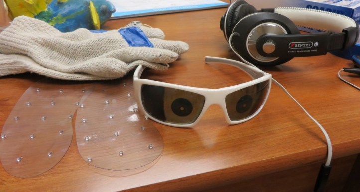 Partially obstructed glasses, gloves with fingers taped and headphones help simulate dementia.